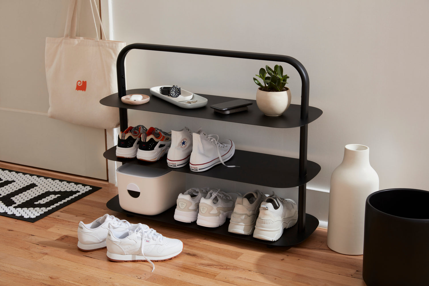 The Black Entryway Rack placed in an entryway with shoes and other Open Spaces products displayed on it.