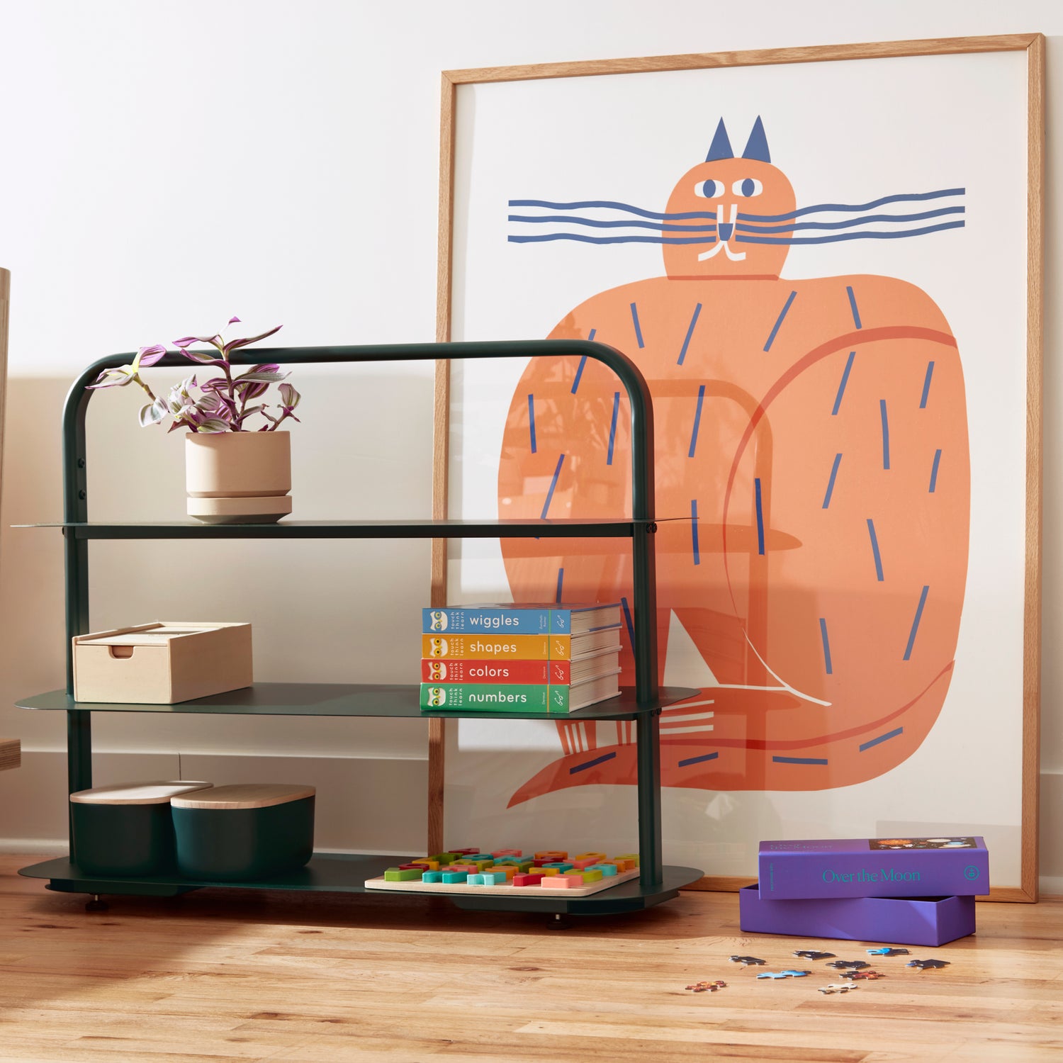 The Dark Green Entry way Rack with items displayed on it on a wooden surface with a painting of a cat on the back.