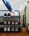 The Open Spaces Dark Green Entryway Rack on a white background with shoes displayed on it.