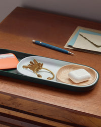 Close up view of The Open Spaces Dark Green Nesting Tray with items on it on a wooden surface