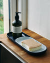 The Open Spaces Navy Nesting tray with dishwashing liquid and sponge on a wooden surface.