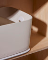 Close up side view for the Open Spaces Large Cream Storage Bin on a wooden surface.