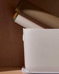 Close up side view for the Open Spaces Large Cream Storage Bin with rolls of paper stored in it.