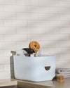 The Open Spaces Light Blue Medium Storage Bin with cleaning supplies on a white marble background.