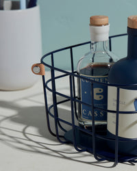 A close up of the Open Spaces Navy Medium Wire Basket with bottles inside it.
