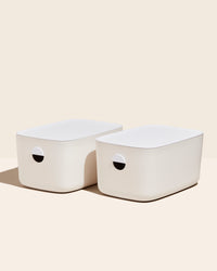 Two Open Spaces Large Cream Storage Bins with plastic lids on a cream background. 