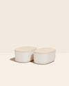 Two Small Cream Storages Bins with wooden lids on a cream background.